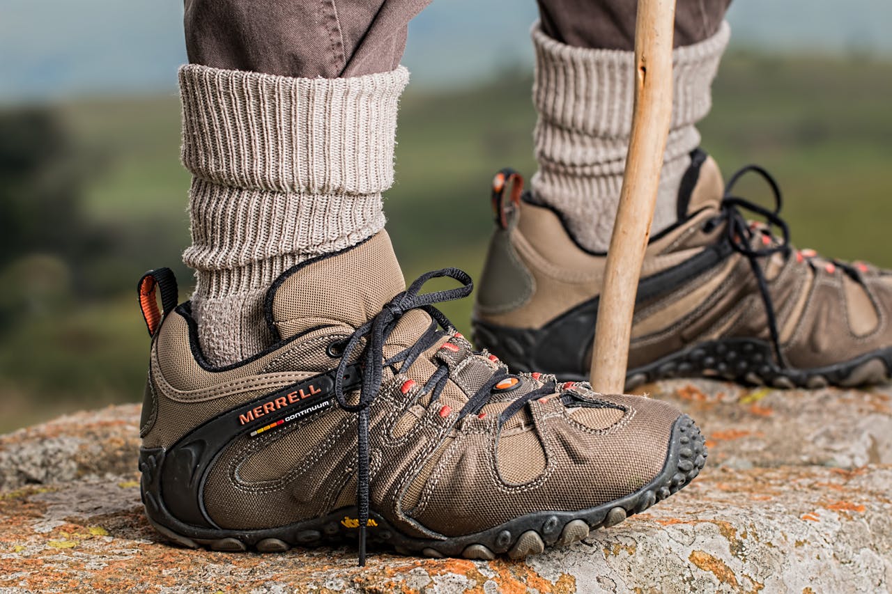 Hiking boots by Merrell on a rock edge, featuring outdoor adventure gear.